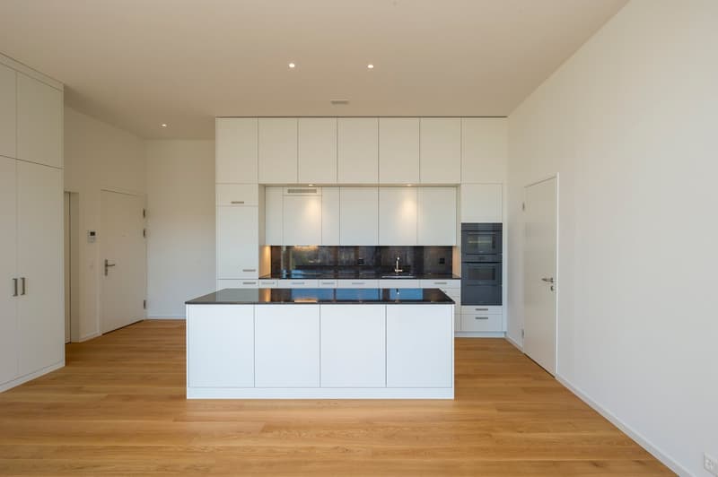 modern kitchen with island, white cabinets, black granite countertop, stainless steel appliances, tiled backsplash, recessed lighting