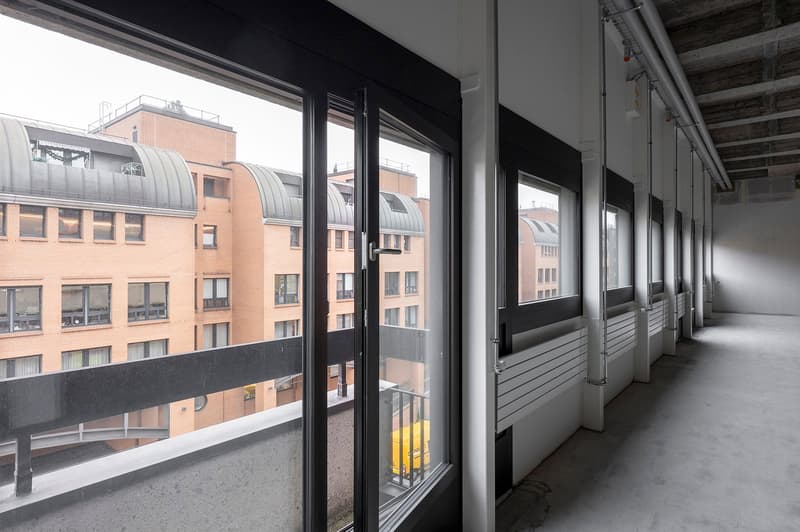 empty corridor, large windows, doors, balconies, view of other buildings