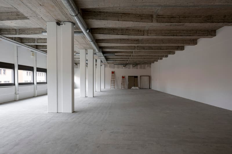 industrial style office space, concrete floors, metal beams, empty rooms, windows