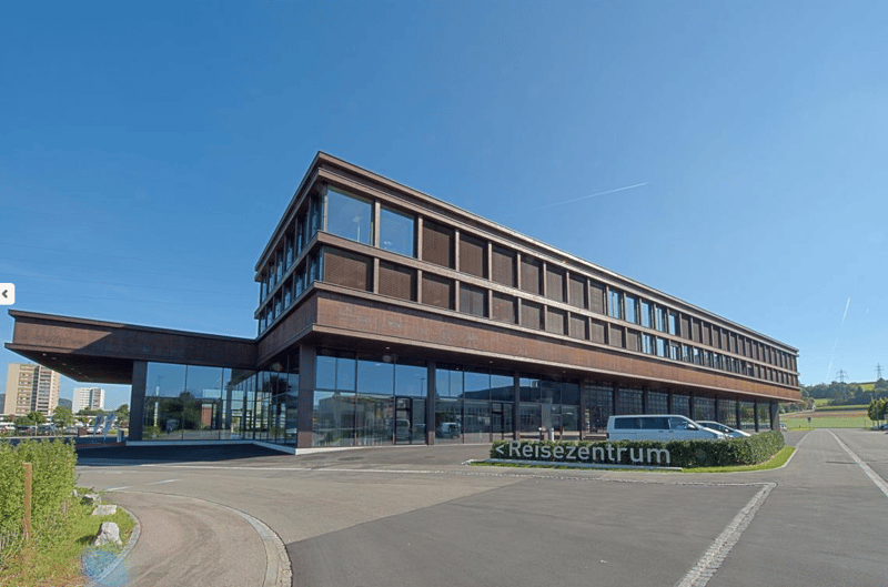 modern office building, large glass facade, brown facade, large parking lot, cars parked in front