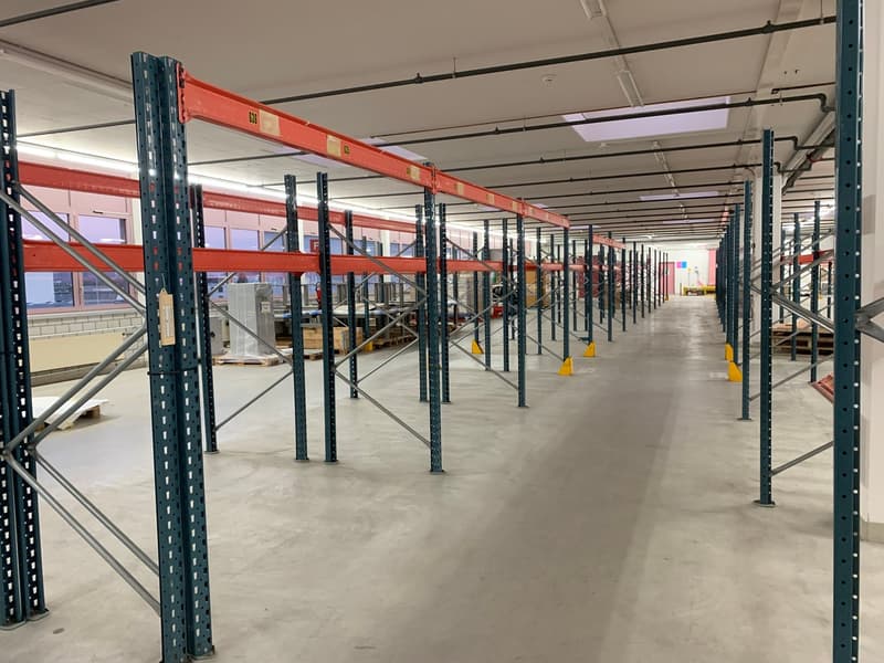 large warehouse with multiple racks and a clean concrete floor