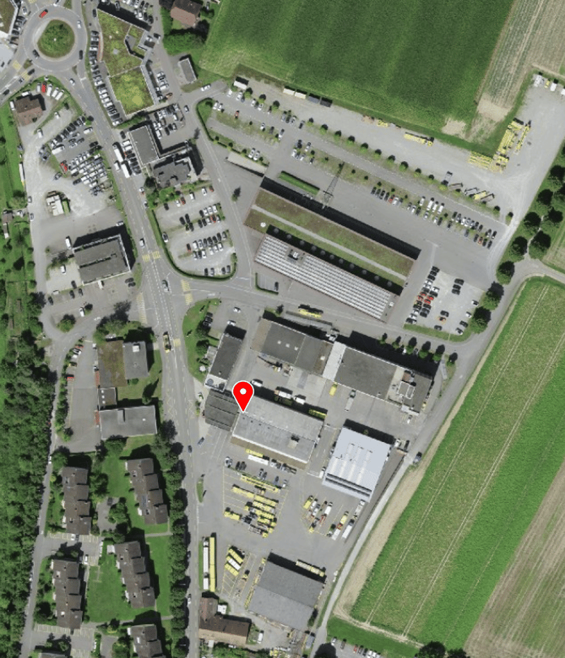Industrial area with multiple buildings, parking lots, and vehicles
