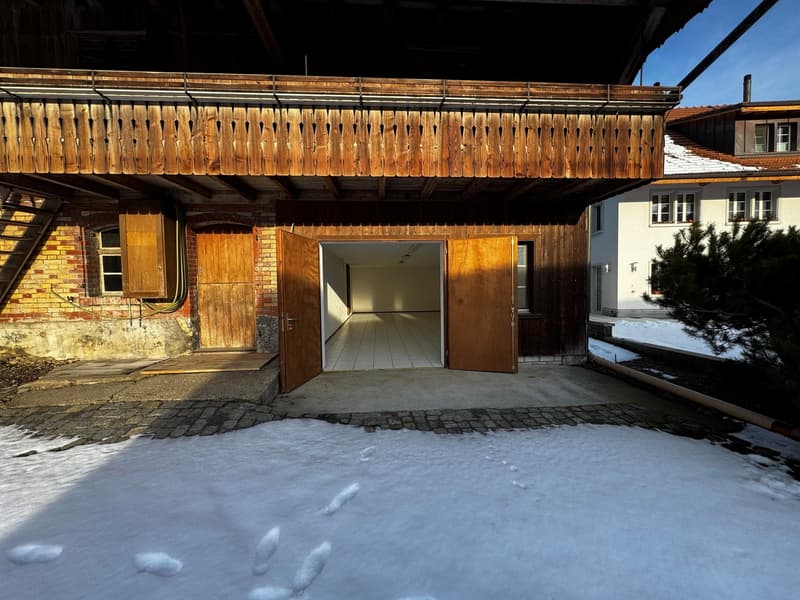 Building: raised ground floor, wooden doors, brick walls, snowy area, chimney, adjacent building, front balcony