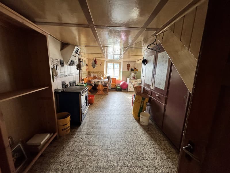 Kitchen: tiled floor, wooden shelves, gas stove, cabinets, yellow buckets, white bucket