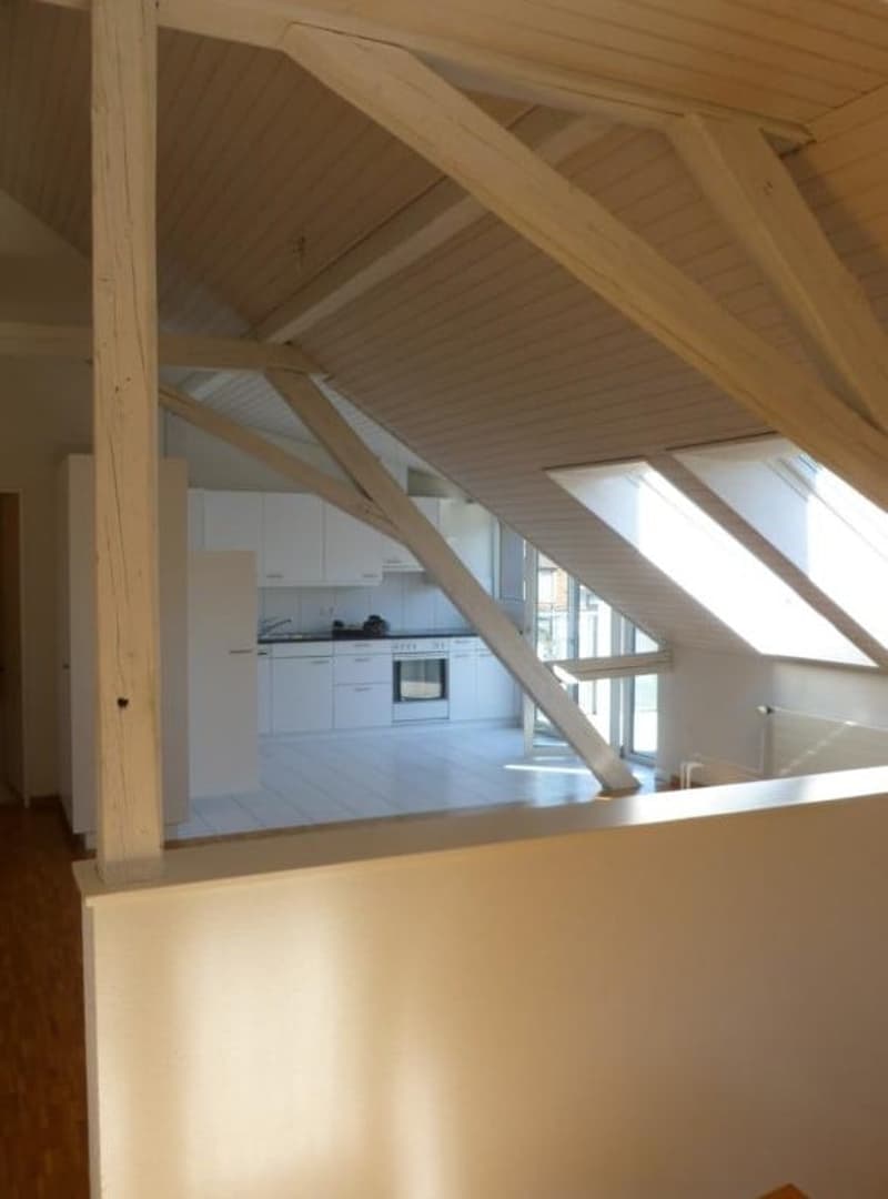 Attic room, white walls, wooden beams, kitchen area, oven, sink