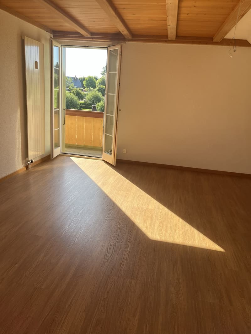 Helles, gemütliches Zimmer mit warmem Holzboden und direktem Balkonzugang