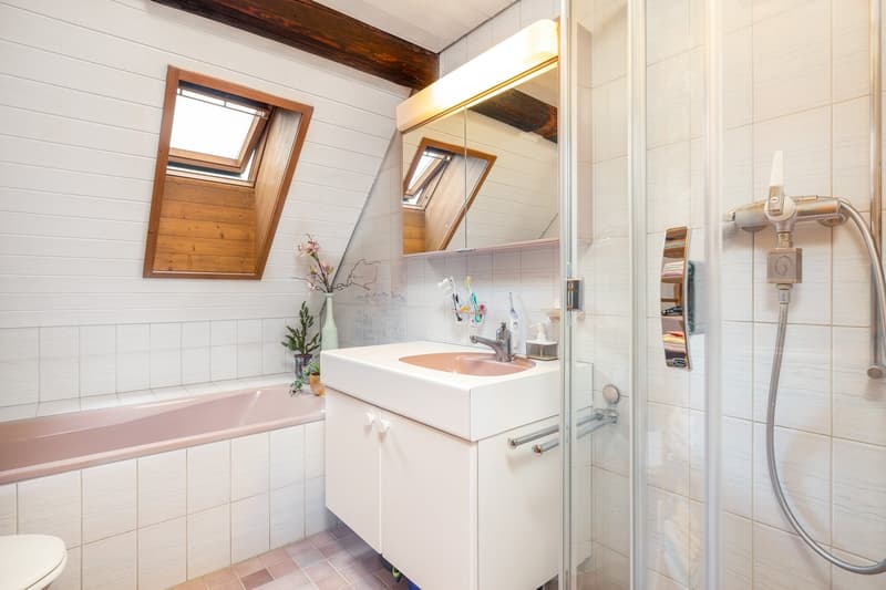 Bathroom with bathtub, sink, mirror, shower, toilet, wooden ceiling, white tiles, pink tiles on the floor
