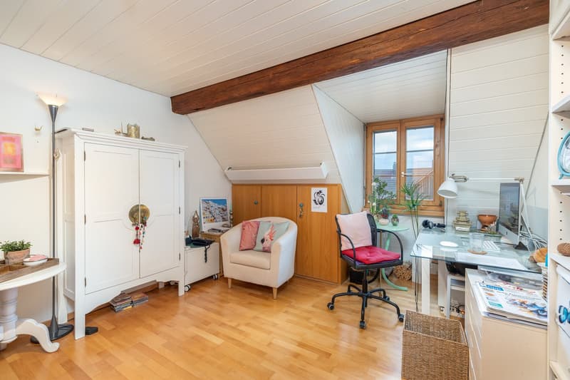 wooden floor, white cabinets, white and wooden chair, office desk with computer, desk lamp, window with curtains