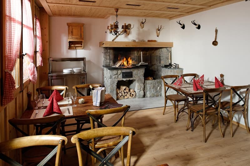 Wooden floor, wooden furniture, fireplace, dining tables, chairs, napkins, wine glasses