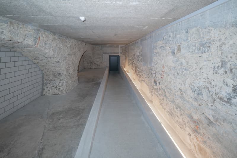 arched concrete pathway, stone walls, concrete floor, tile wall, security camera