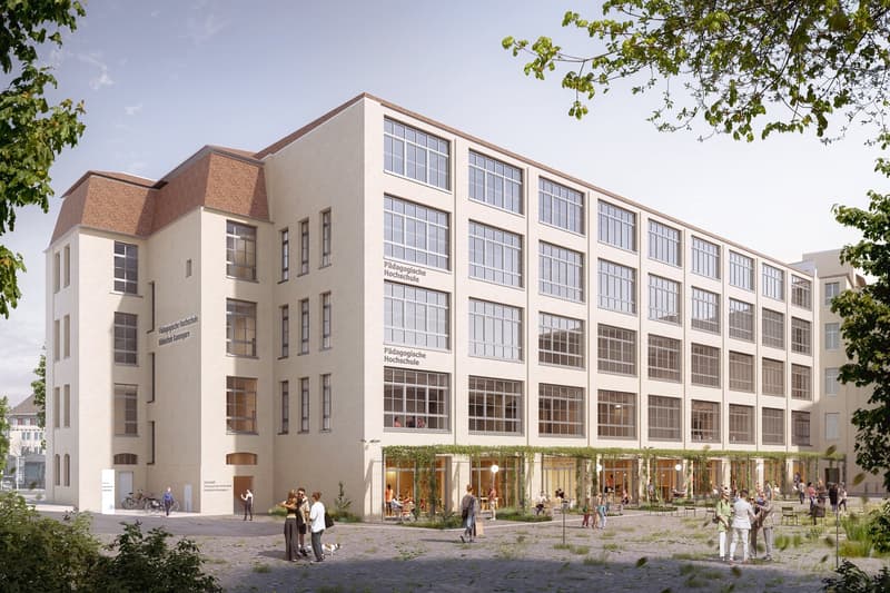 Multi-story educational building, glass windows, green rooftop, multiple entrances, outdoor seating area