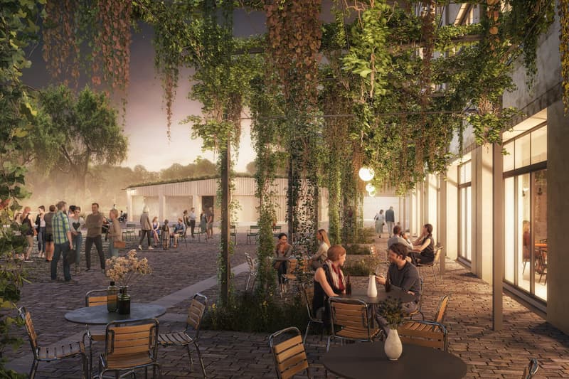 Outdoor seating with a roof made from hanging vines, tables, chairs, and people walking around.