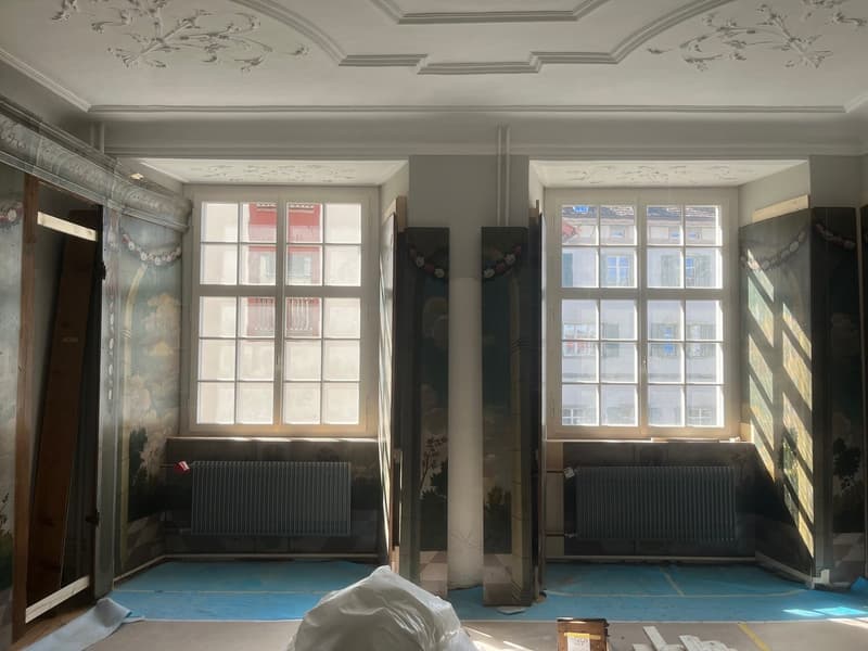 Sicht auf Fensterfront und Wandtäfer mit Malerei