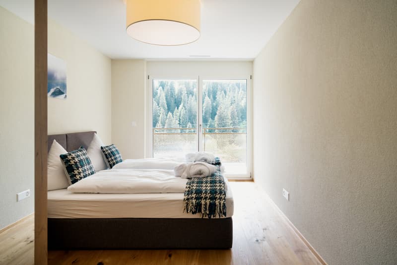 Helles Schlafzimmer mit direktem Zugang zum Balkon und schönem Blick ins Grüne ein ruhiger Rückzugsort für erholsame Ferienmomente.