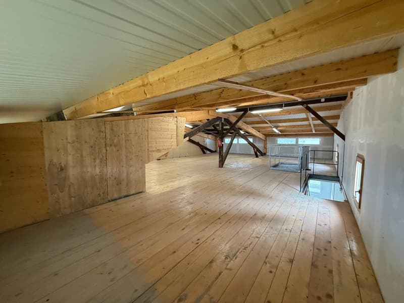spacious room, wooden floor, wooden beams, metal railings, windows