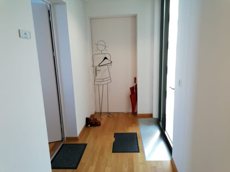 Empty room, hardwood floor, glass doors, open doorway, coat rack, red umbrella