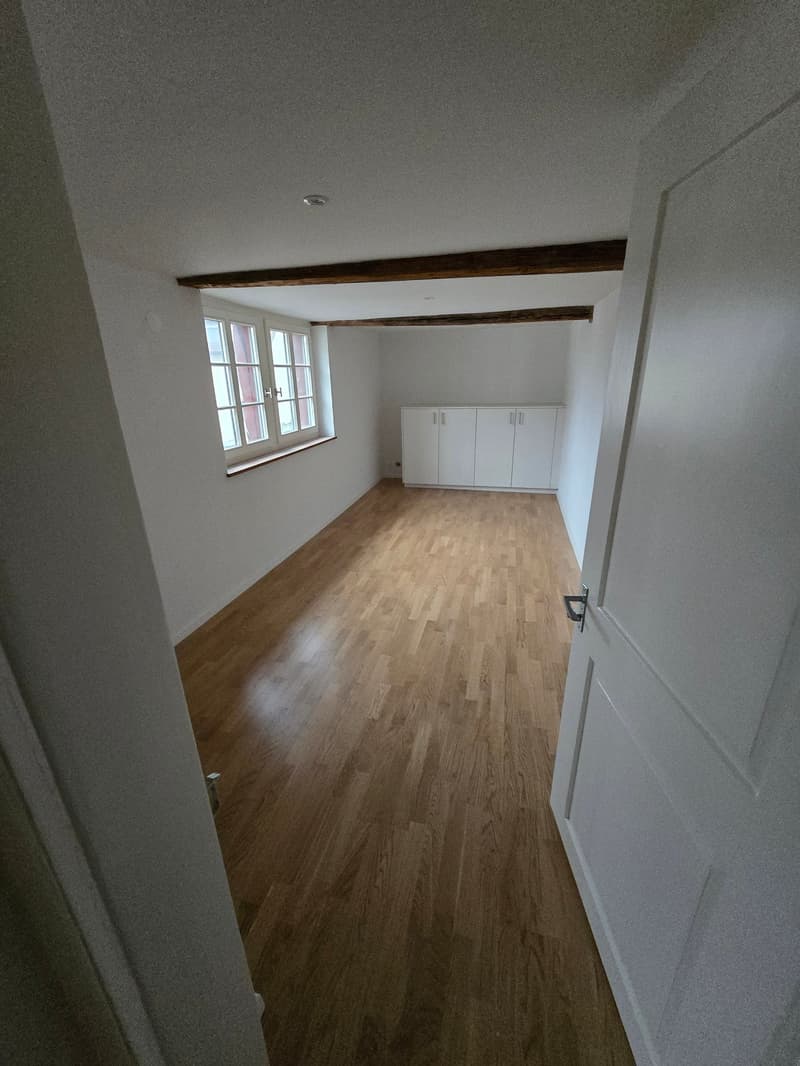 Empty room, hardwood floors, windows, white cabinets