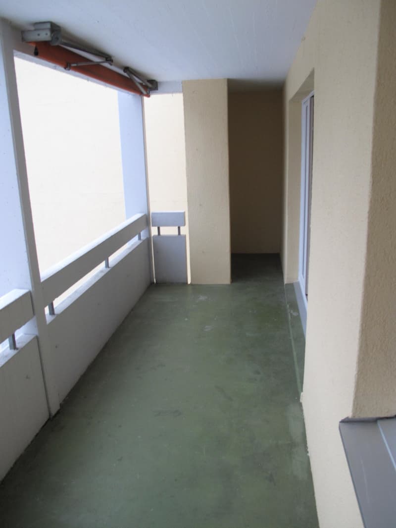 Empty balcony with white railings and green floor