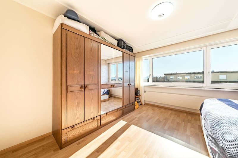 large wooden wardrobe, large windows, wooden floor, bed