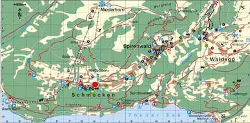 This is a topographic map of a mountainous region. It shows various towns and villages, as well as roads and hiking trails. The map indicates the presence of a parking area or lot in one of the locations.