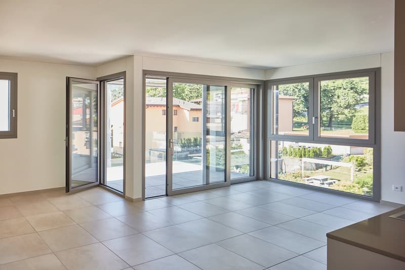 large sliding glass doors, balcony, tiled floor, large windows, view of garden