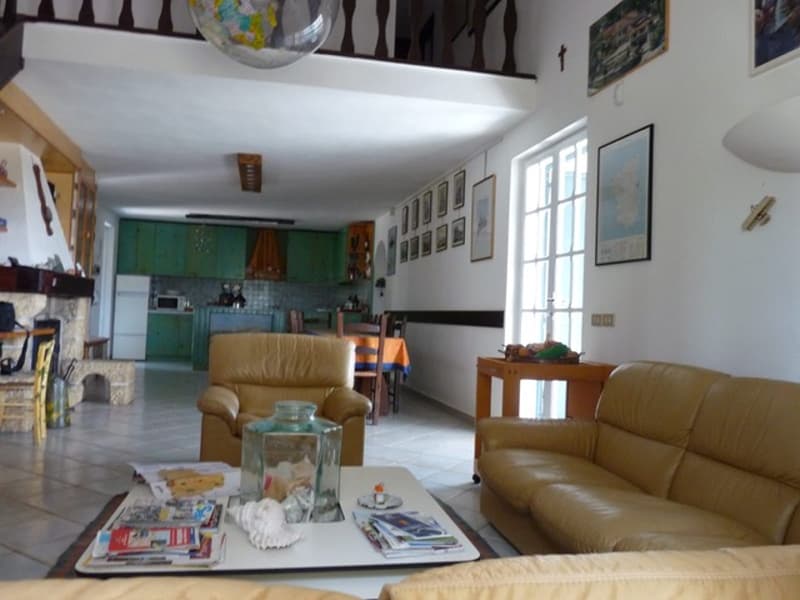Fireplace, tile flooring, leather sofa, center table, kitchen, dining table, chairs