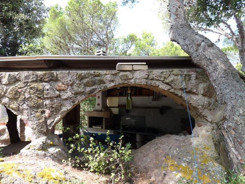 House made from stone, stone arch entrance, open kitchen, natural surroundings