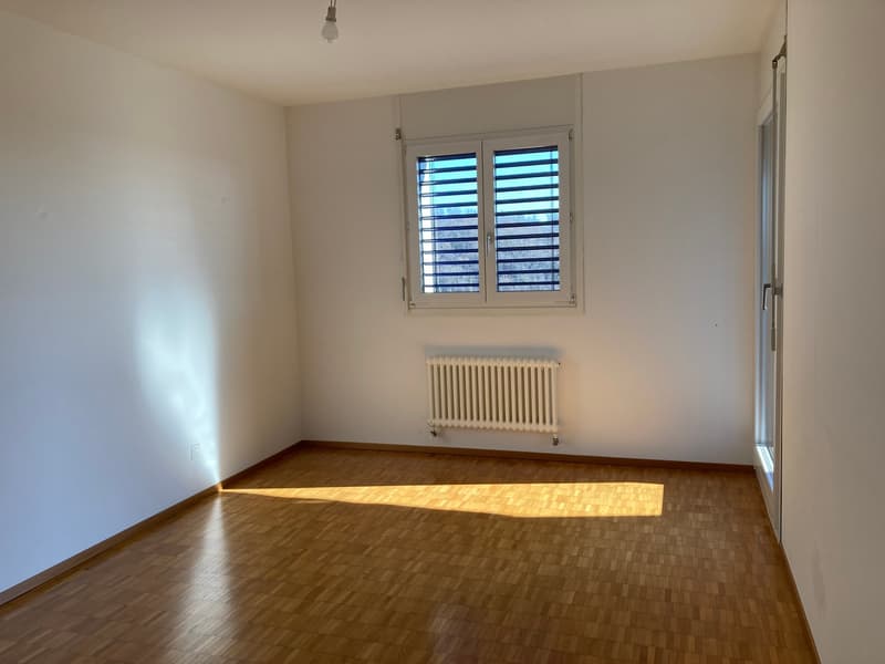 empty room, white walls, wooden floor, white radiator, windows with shutters