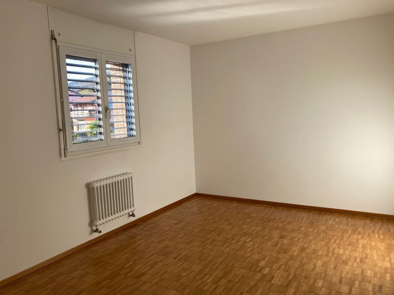 empty room, white walls, white radiator, wooden floors, window with shutters
