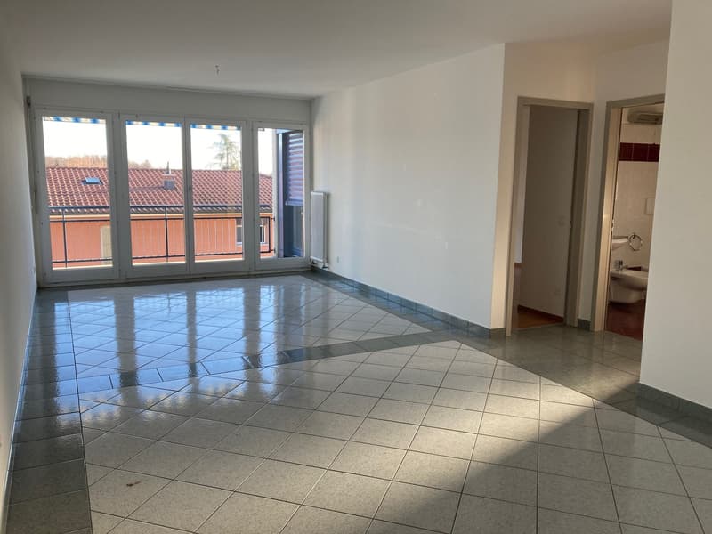empty room, tiled floor, large windows with balcony, white walls, radiators, door to the right