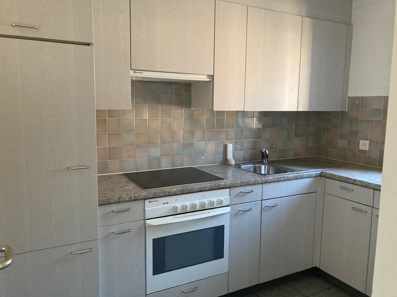 kitchen with cabinets, countertop, stove, sink, tiles on wall, electrical outlet