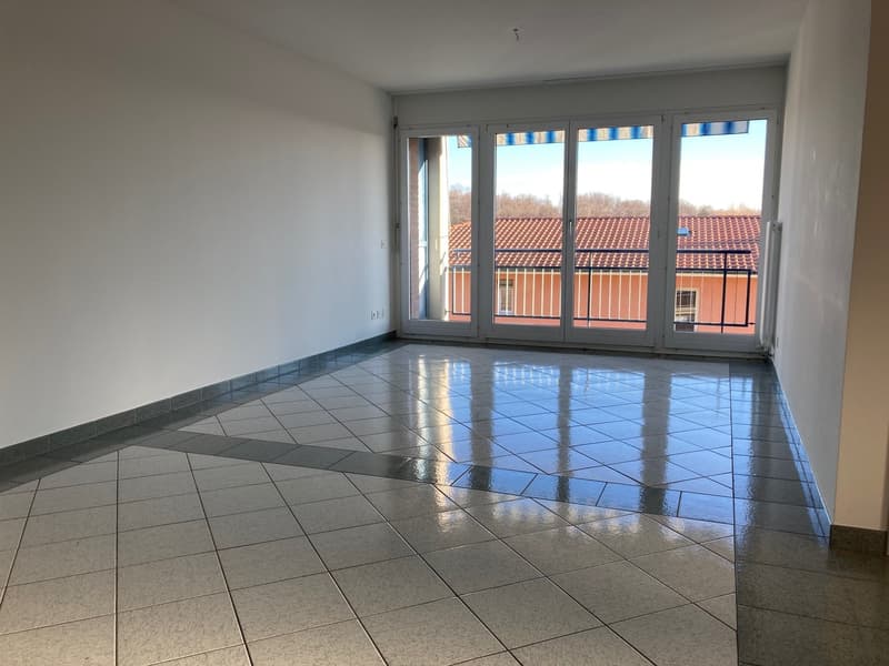 Empty room with sliding doors leading to a balcony, tiled floor, white walls