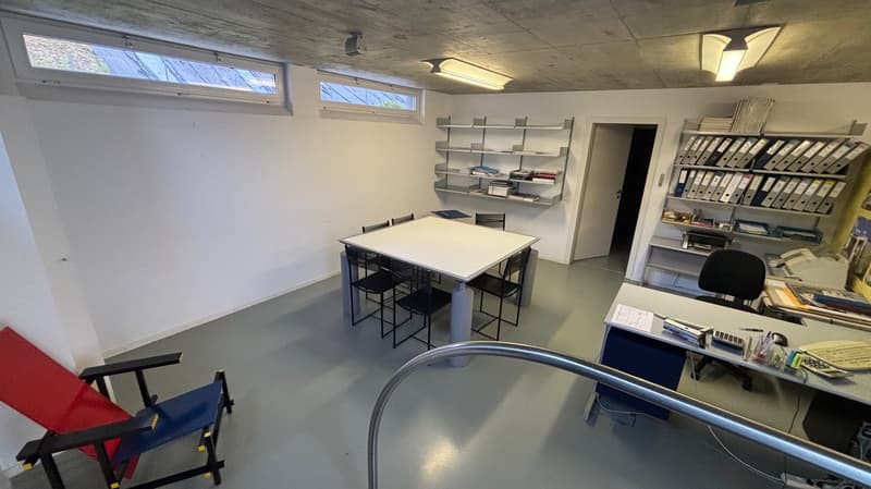 Office room, table with chairs, shelves with files, desks, lamps