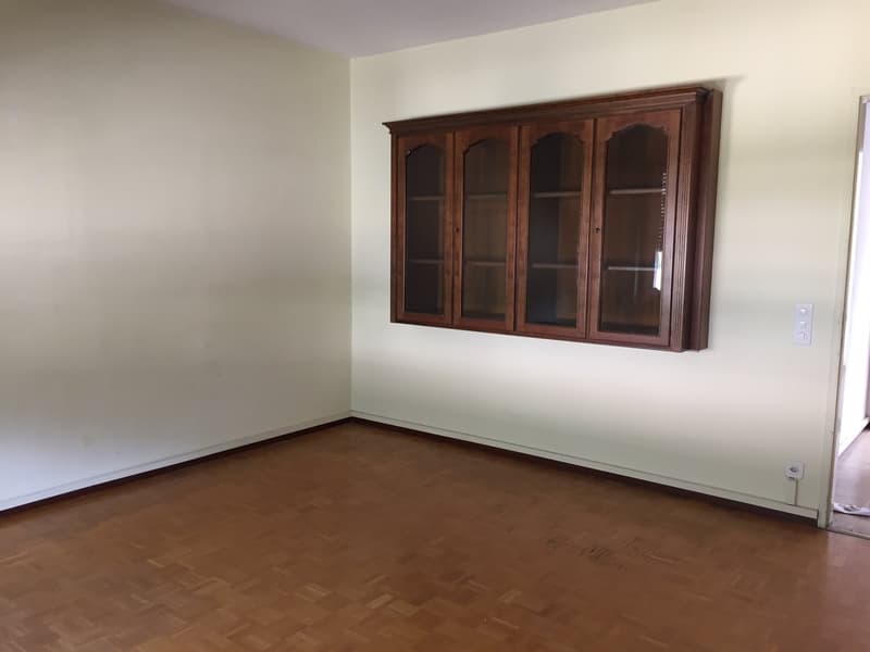 empty room, wooden floor, white walls, wooden cabinet with glass doors