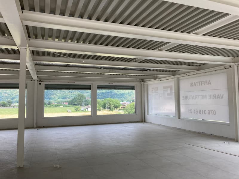 Empty room with large windows, white ceiling, tiled floor, and a view of the outside landscape