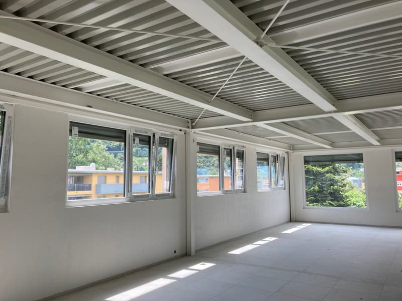 empty room, white walls, white ceiling, white tiled floor, large windows, view of trees and buildings