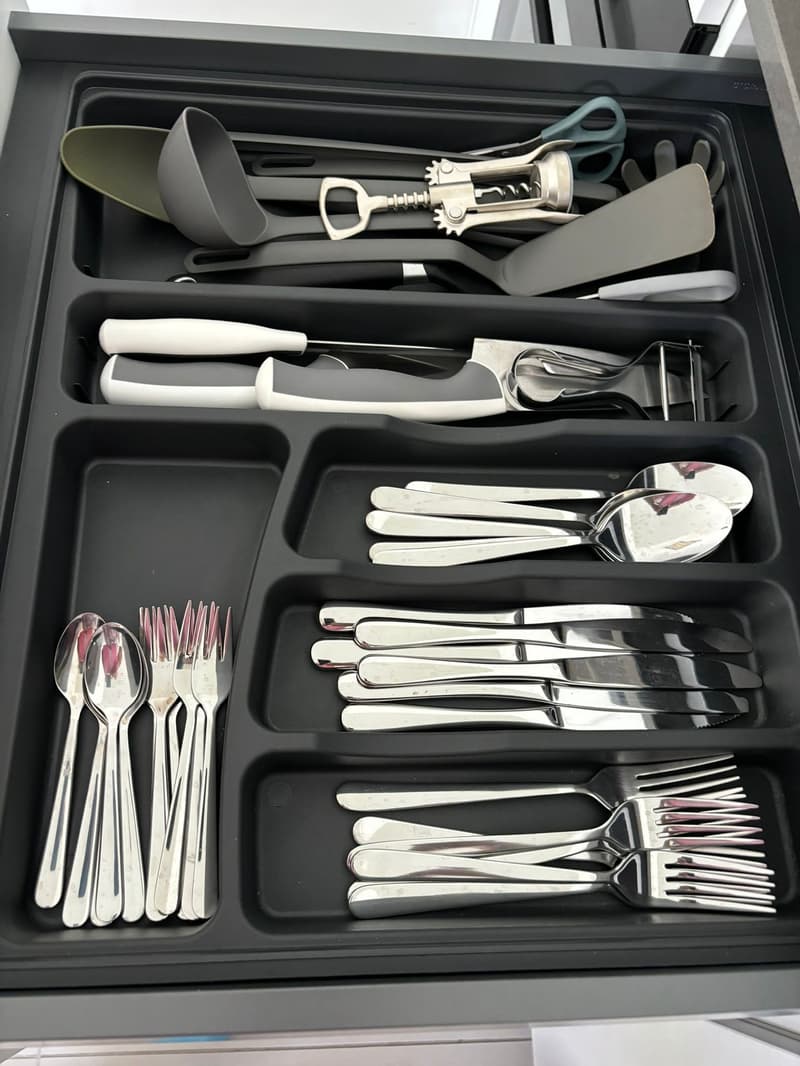 Drawer organized with cutlery, utensils, and kitchen tools
