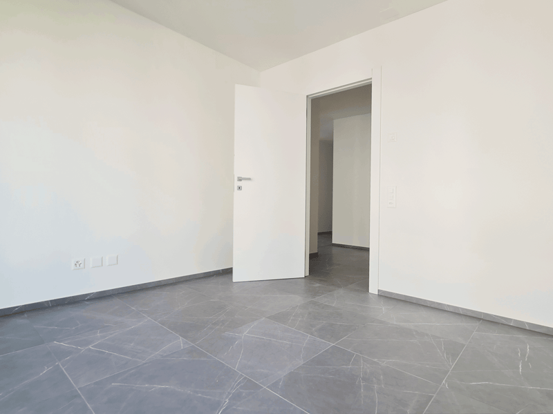 empty room, white walls, gray tiles, open door, electrical outlet