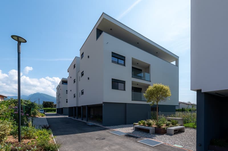 modern white multi-story building, garage, balconies, driveway