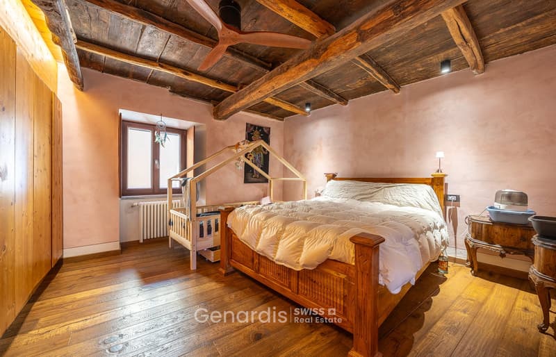 bedroom with wooden floor, wooden bed, wooden crib, wooden wardrobe, pink wall, wooden ceiling, window, radiator, lamp, table, bowl