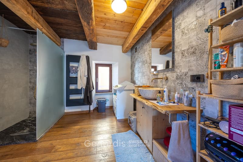 bathroom with wooden floor, wooden ceiling, shower, sink, mirror, wooden shelves, towel rack, trash bin, towel, toiletries