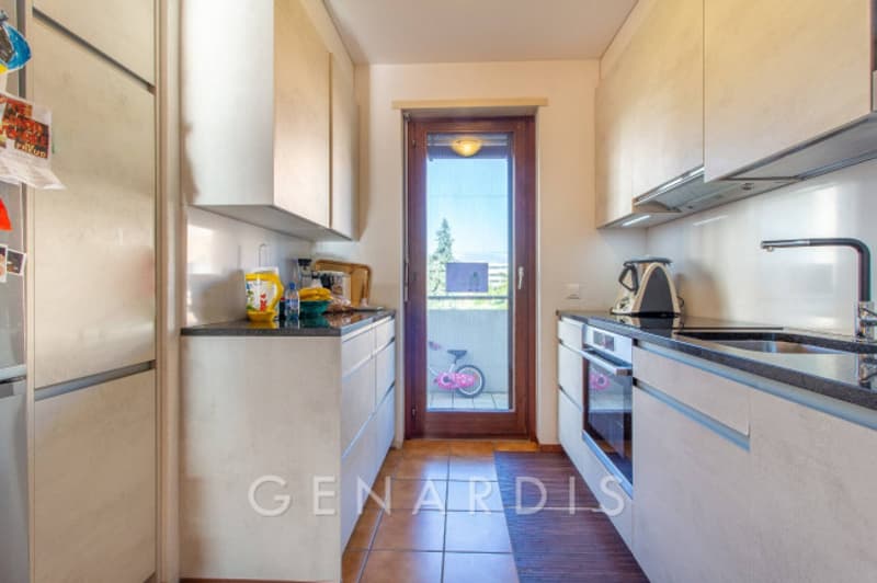 modern kitchen with white cabinets, granite countertops, stainless steel appliances, wooden floor, sink, oven, dishwasher, washing machine