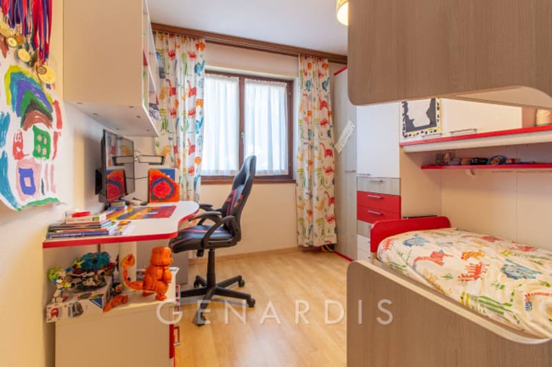 Children's room with desk, chair, bunk bed, toys, curtains, paintings, wooden floor