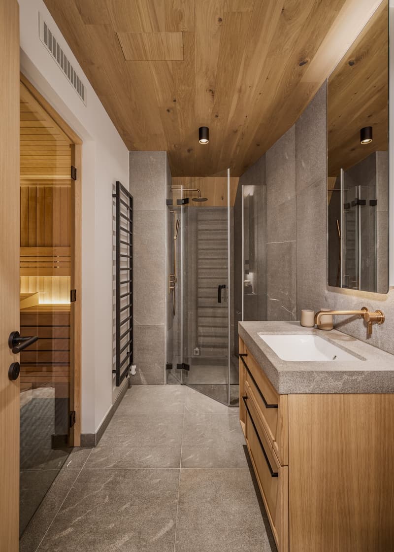 Bathroom with wooden ceiling, gray tiles, wooden cabinet, sink, shower, sauna