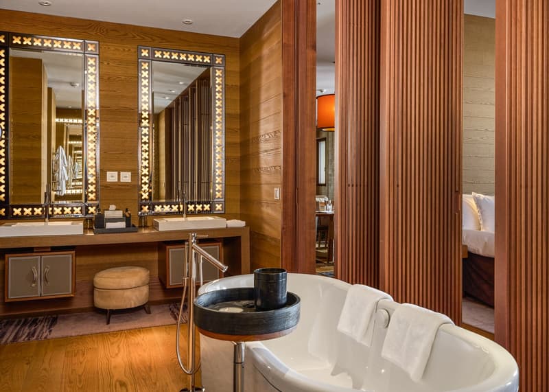 wooden walls, large mirrors, double sinks, large bathtub, wooden tray, towels