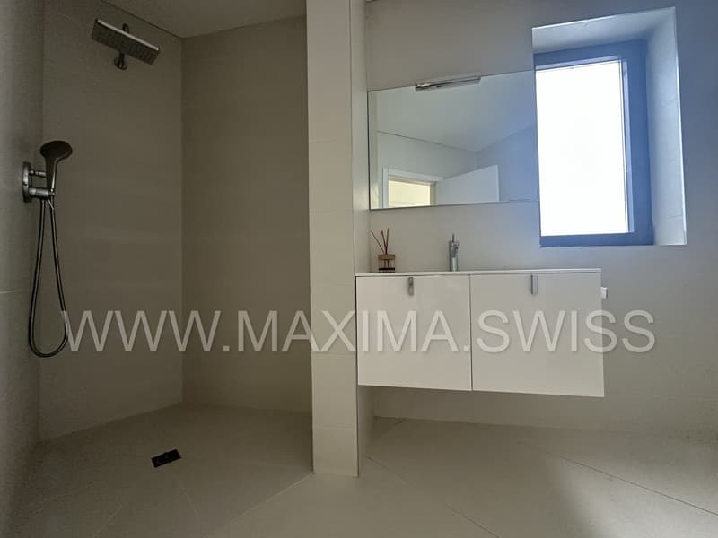 modern bathroom with shower, sink, mirror, and window