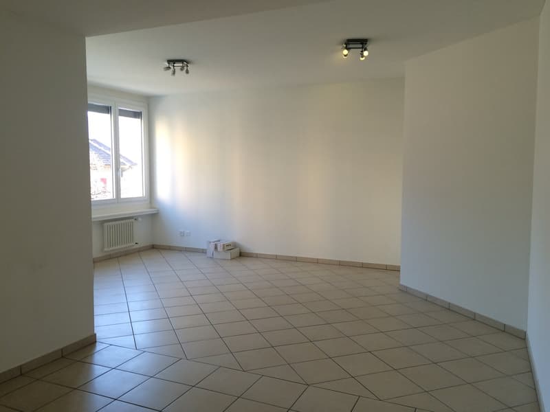 Empty room, white walls, tiled floor, radiator, window, boxes on the floor