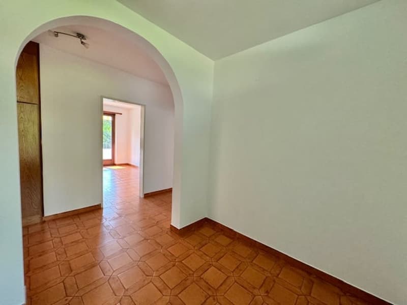 empty room, wooden tile floor, arched doorway, white walls