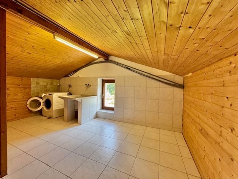 small laundry room, wooden walls, white tiled floor, washing machine, sink, window