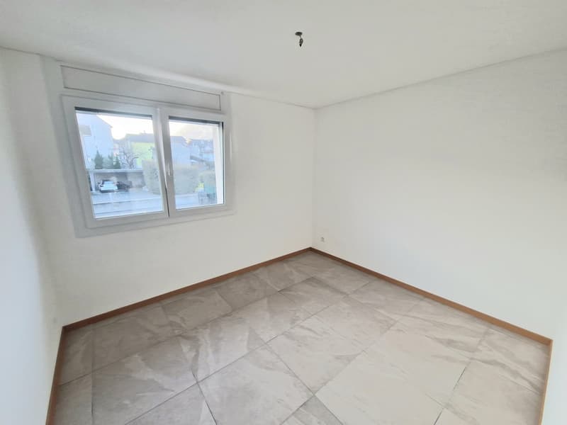 empty room, white walls, tiled floor, single window with outdoor view